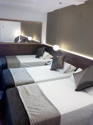 a group of four beds in a room at Moderno in Barcelona