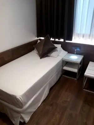 a large white bed in a room with a table at Moderno in Barcelona