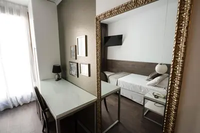 a mirror in a bedroom with a bed and a desk at Moderno in Barcelona