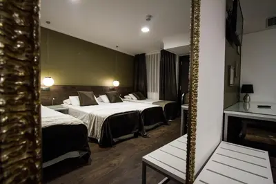 a hotel room with two beds and a mirror at Moderno in Barcelona