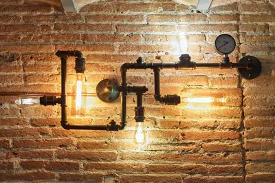 a light hanging on a brick wall with a clock at BBarcelona Dúplex Poble Sec in Barcelona