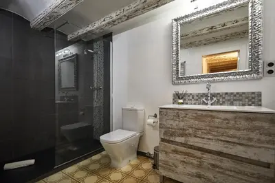 a bathroom with a toilet and a sink and a mirror at BBarcelona Dúplex Poble Sec in Barcelona