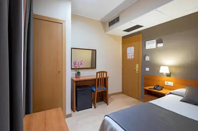 a hotel room with a bed and a desk at Catalunya in Barcelona