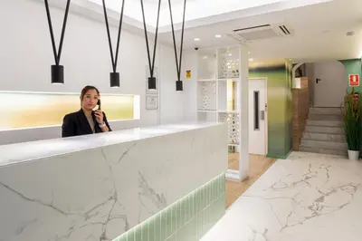 a woman standing behind a counter talking on a cell phone at Catalunya in Barcelona