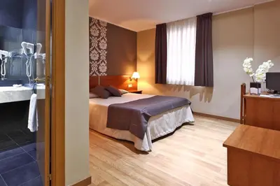 a hotel room with a bed and a bathroom at Catalunya in Barcelona