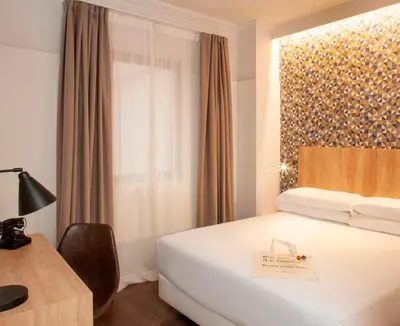 a hotel room with a bed and a window at Chic & Basic Velvet in Barcelona