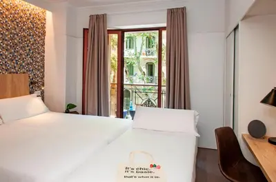 a hotel room with two beds and a window at Chic & Basic Velvet in Barcelona