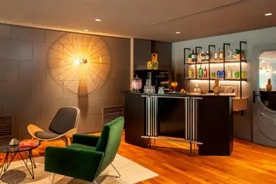 a room with a bar with chairs and a table at Chic & Basic Velvet in Barcelona