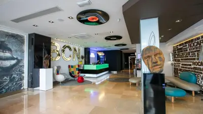 a lobby of a store with a giant head on the wall at Evenia Rocafort in Barcelona
