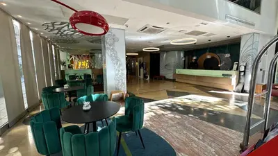 a restaurant with two tables and green chairs at Evenia Rossello in Barcelona