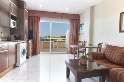 a kitchen and living room with a couch and a table at Sunway Playa Golf & Spa Sitges in Sitges