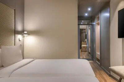 a bedroom with a white bed and a television at AC Hotel Som by Marriott in Hospitalet de Llobregat