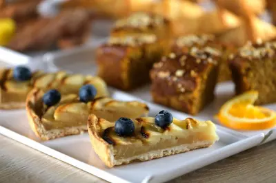 a plate of dessert items with blueberries and orange slices at AC Hotel Som by Marriott in Hospitalet de Llobregat