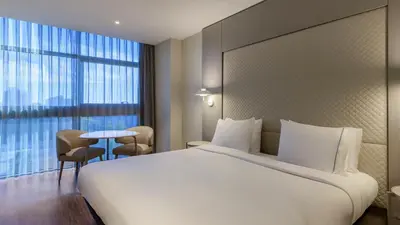 a hotel room with a large bed and a table at AC Hotel Som by Marriott in Hospitalet de Llobregat