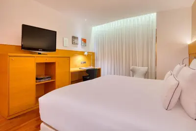a hotel room with a bed and a television at Sansi Pedralbes in Barcelona