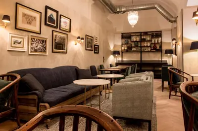 a living room with a couch and tables and chairs at Hotel Midmost by Majestic Hotel Group in Barcelona