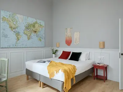 a bedroom with a bed with a yellow blanket on it at Casa Cosi Patio 1 in Barcelona