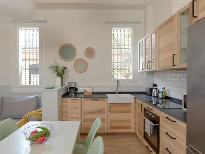 a kitchen with wooden cabinets and a table with a bowl on it at Casa Cosi Patio 1 in Barcelona