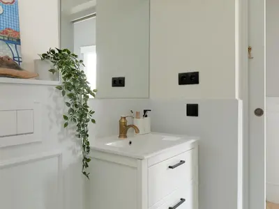 a white bathroom with a sink and a mirror at Casa Cosi Patio 1 in Barcelona