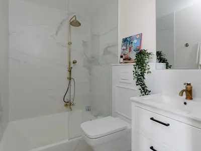 a white bathroom with a toilet and a sink at Casa Cosi Patio 1 in Barcelona