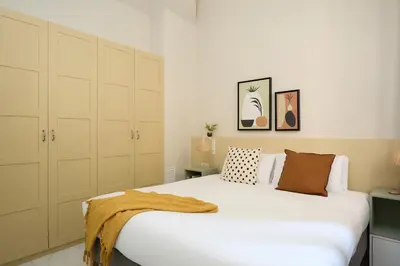 a bedroom with a large white bed and cabinets at Casa Cosi Don Bajos in Barcelona