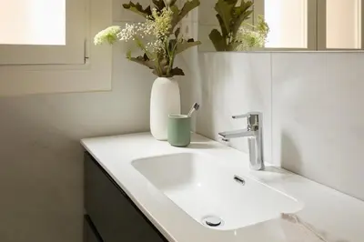 a bathroom sink with a vase with flowers in it at Casa Cosi Don Bajos in Barcelona