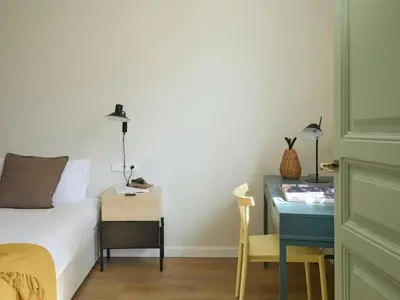 a bedroom with a bed and a desk next to a bed at Casa Cosi El Farro 4 in Barcelona