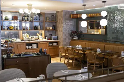 a restaurant with tables and chairs and a counter at Via Sants Hotel Barcelona, Tapestry Collection By Hilton in Barcelona