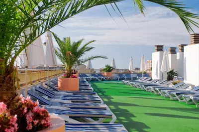 a row of chaise lounge chairs on the roof of a resort at Mercè in Pineda de Mar