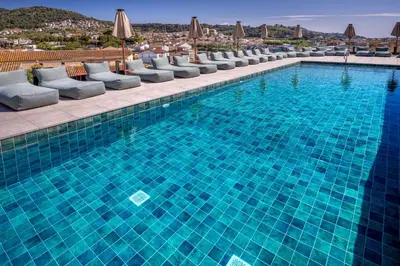 a large swimming pool with chairs and umbrellas at Mercè in Pineda de Mar