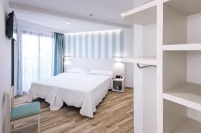 a bedroom with a white bed and a large window at Mercè in Pineda de Mar