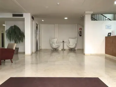 a hospital lobby with two chairs and a table at BCN Urbaness Hotels Del Comte in Barcelona