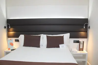 a bedroom with a large bed with a black headboard at BCN Urbaness Hotels Del Comte in Barcelona