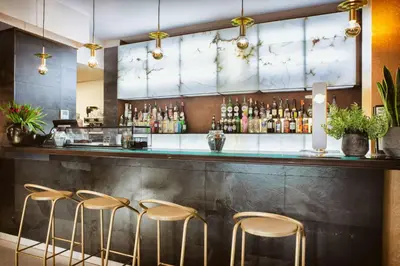 a bar with four stools in front of a counter at Best Western Plus Hotel Alfa Aeropuerto in Barcelona