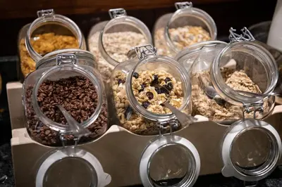 a bunch of different types of food in glass jars at Catalonia Barcelona Beach in Barcelona