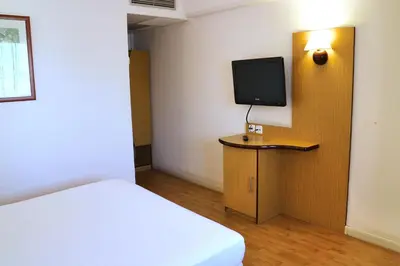 a bedroom with a bed and a tv on a wall at Travelodge Barcelona del Vallés in Barbera del Valles