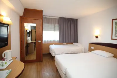 a hotel room with two beds and a television at Travelodge Barcelona del Vallés in Barbera del Valles