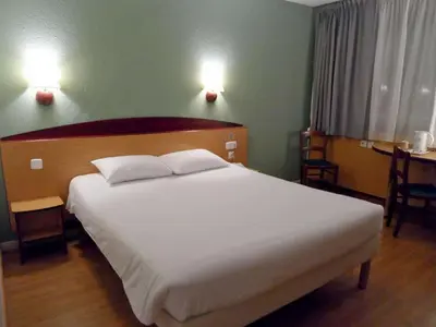 a bedroom with a large white bed with two pillows at Travelodge Barcelona del Vallés in Barbera del Valles
