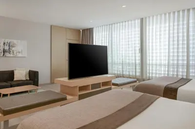 a hotel room with a flat screen tv and a bed at AC Hotel Victoria Suites by Marriott in Barcelona