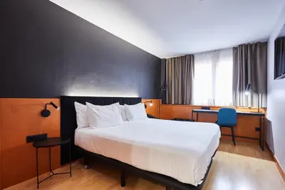 a hotel room with a bed and a desk at Silken Sant Gervasi in Barcelona