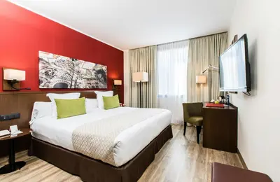 a hotel room with a bed and a flat screen tv at Leonardo Hotel Barcelona Gran Via in Barcelona