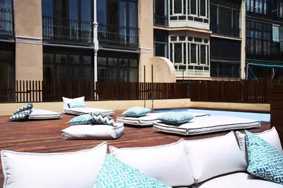 a group of pillows sitting on a wooden table with buildings at TOC Hostel Barcelona in Barcelona