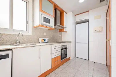 a kitchen with white cabinets and a microwave at Apartaments Marina - Abapart in Barcelona