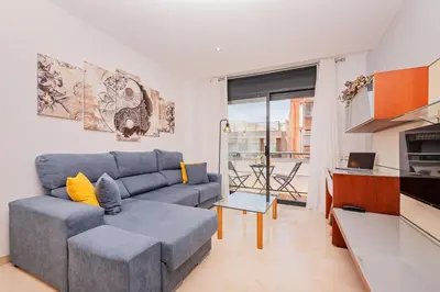 a living room with a blue couch and a table at Apartaments Marina - Abapart in Barcelona
