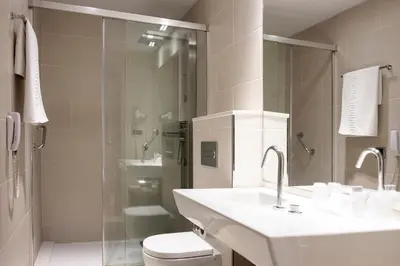 a bathroom with a shower and a toilet and a sink at Hotel Lleó in Barcelona