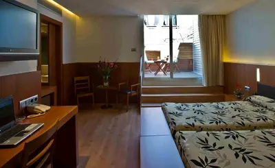 a hotel room with a bed and a desk with a computer at Hotel Lleó in Barcelona