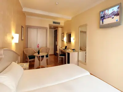 a hotel room with a bed and a tv on the wall at Hotel Lleó in Barcelona