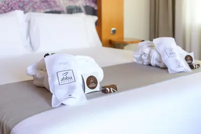 a hotel room with towels and chocolate on a bed at Abba Sants in Barcelona