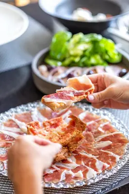 a person holding a piece of food on a table at Abba Sants in Barcelona
