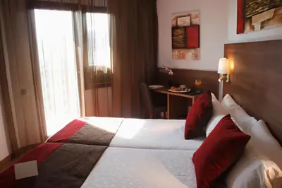 a hotel room with a large bed with red pillows at Hotel Best Auto Hogar in Barcelona